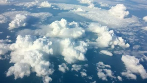 Photorealistic aerial view of diverse cloud formations at different altitudes showing varied cloud densities and structures over ocean landscape, natural lighting, no text or labels visible